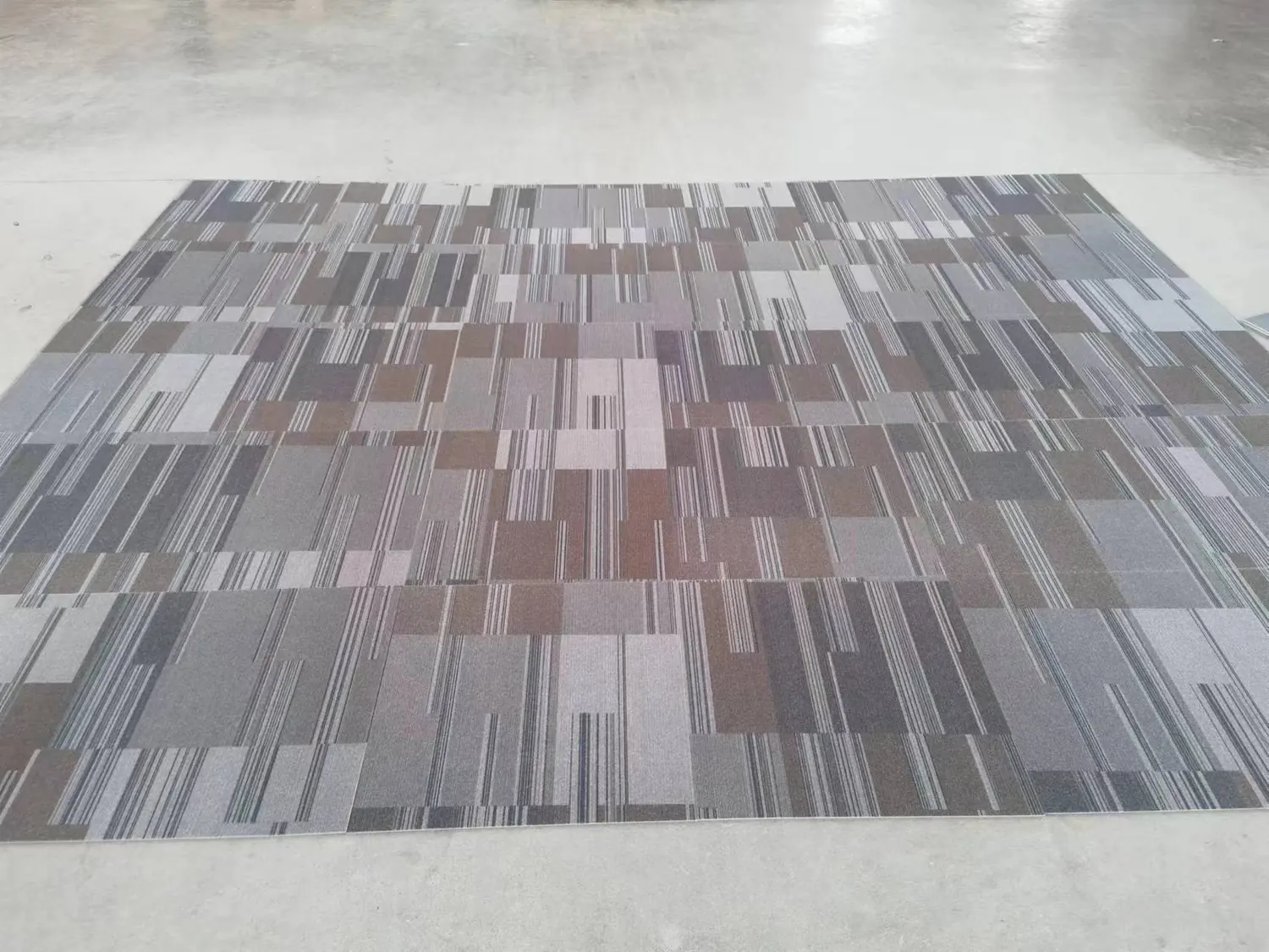 Printed flocked carpet tiles laid out across a warehouse floor